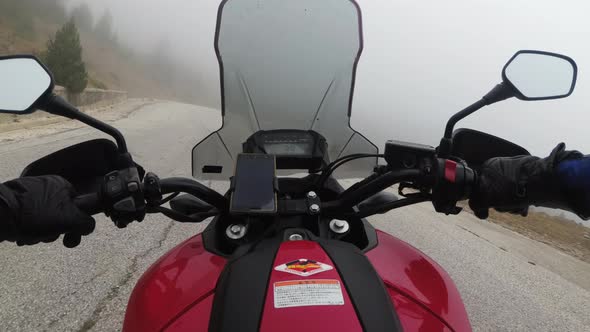 POV Biker on Motorcycle Rides on High Mountain Pass in Cloudy Weather with Fog alt