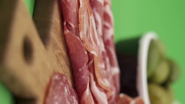 Vertical video, Close-up: cold cuts, salami, prosciutto, jamon, cherry tomatoes, sliced ​​sausage alt