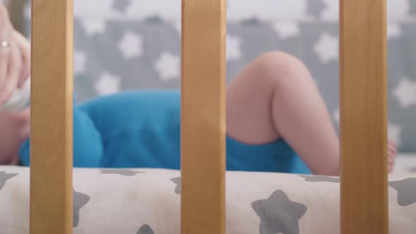 Mommy Feeds Cute Baby with Delicious Milk Mix in Modern Cot alt