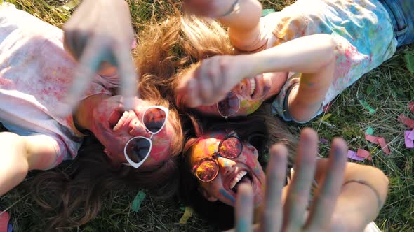 Three happy beautiful female making party at Holi colors festival in summer time alt