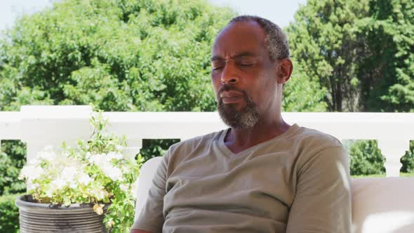 Senior african american man sitting in the balcony at home alt