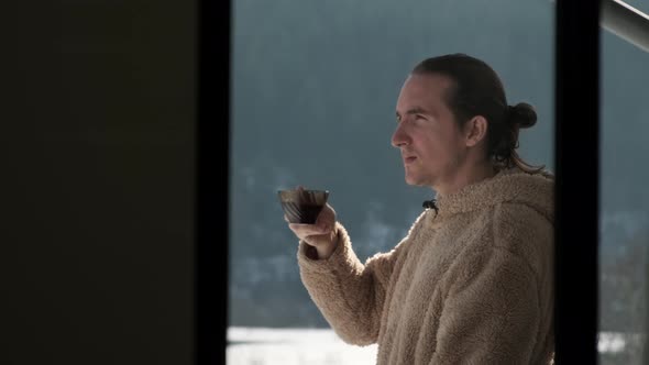 Man drinking tea on balcony. alt