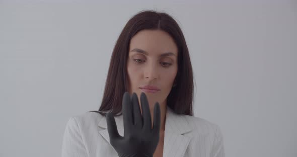 The Beautician Wears Black Gloves For Examination alt