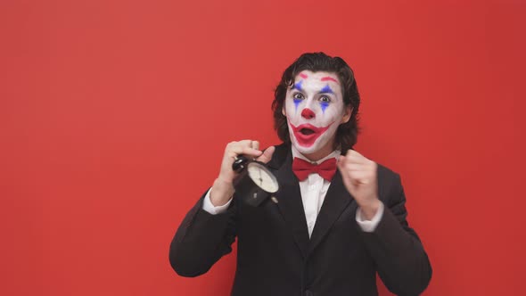 A Strange Clown Dressed in a Black Suit and with Bright Makeup Grimaces Arranges a Performance He
