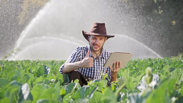 Farmer Shows Thumb To Up During Monitoring His Plantation Using Digital Tablet alt