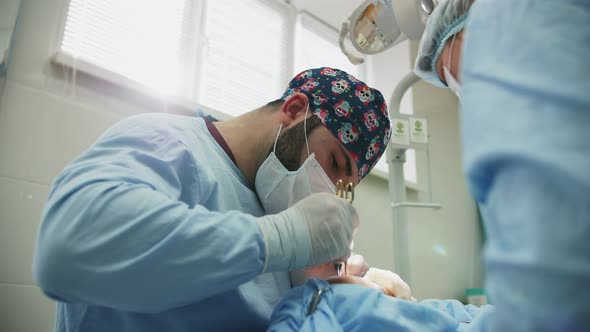 a male surgeon performs an operation alt