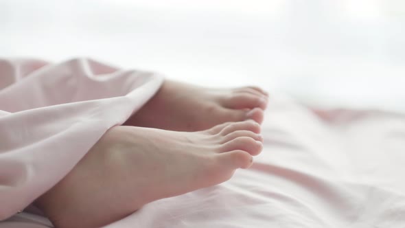 Close Up Kid Feet Sticking Out From Under the Blanket in the Morning Light alt