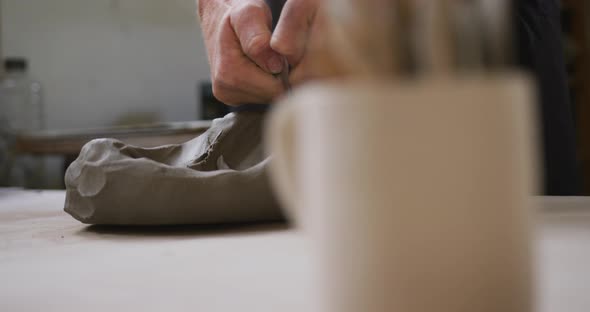 Close up view of male potter kneading the clay at pottery studio alt