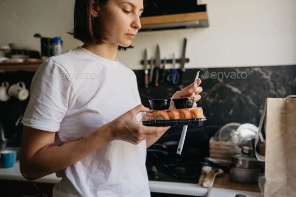 woman holding sushi package, sushi delivery, eating sushi at home, delivery and takeout, order