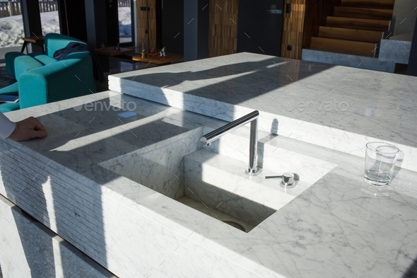 stylish marble sink with faucet in kitchen-living room. modern urban interior design