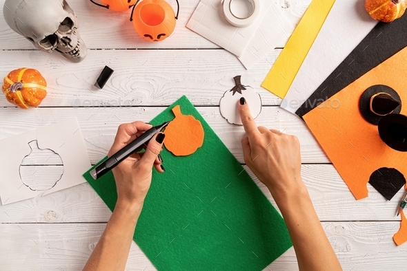 Step by step instruction of making halloween bookmark DIY pumpkin craft. draw out a green part