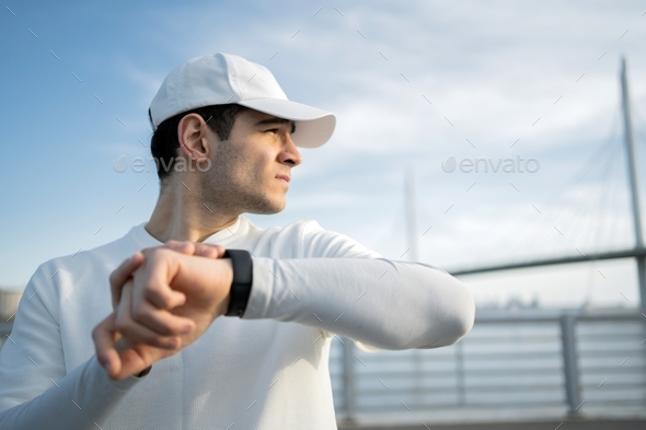 uses smart watch cardio and heart rate, male athlete training fast running outdoors
