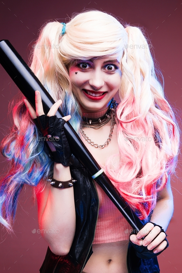 Cosplayer girl with a baseball bat in a Harley Quinn costume. Stock