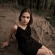 a woman in a black dress sits on the roots of trees - PhotoDune Item for Sale