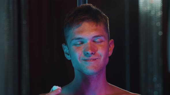 Shirtless Man Eating Coconut Candy and Acting Sexy  Neon Blue and Purple Lighting alt