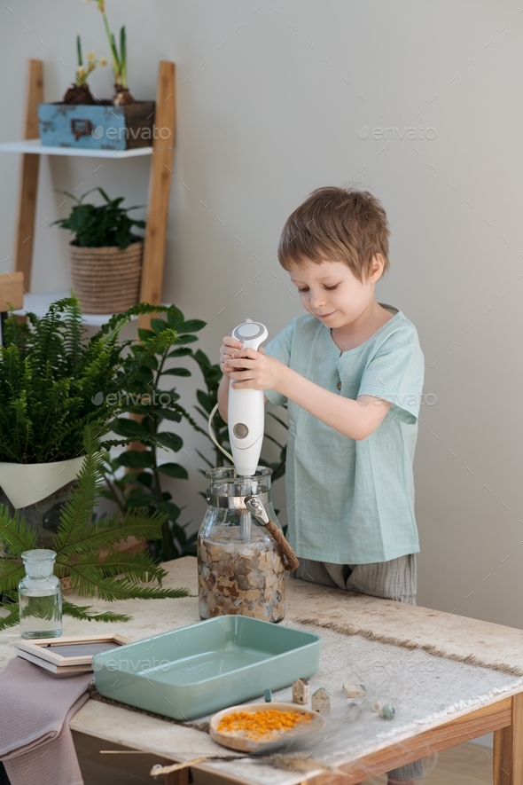 preschooler making pulp from torn or cut up scrap papers using water