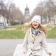 a happy little girl with long hair in a coat walks around an old European city - PhotoDune Item for Sale