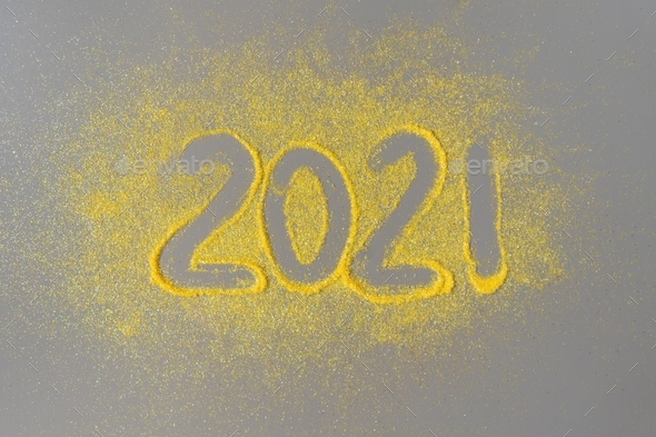Inscription 2021 on a gray background with yellow sparkles. Festive Christmas and New Year concept.