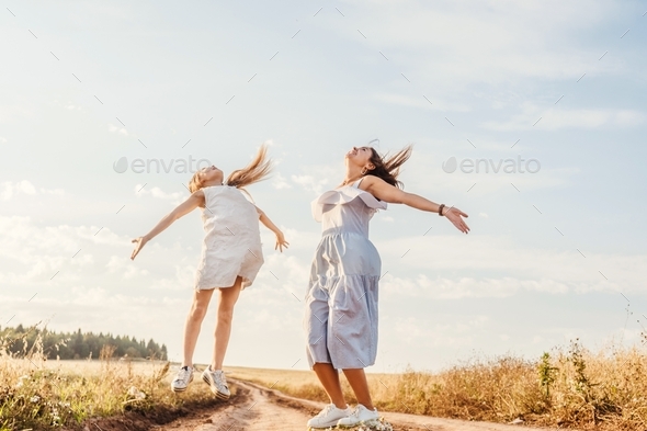 Happy Mother And Daughter Jumping In Field Sky Background Bottom View