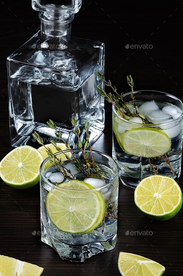 Cocktail with white rum and tonic, a slice of lime and thyme Stock