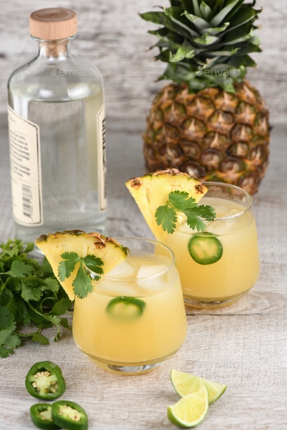 Tequila cocktail with pineapple juice, jalapeno slices and cilantro