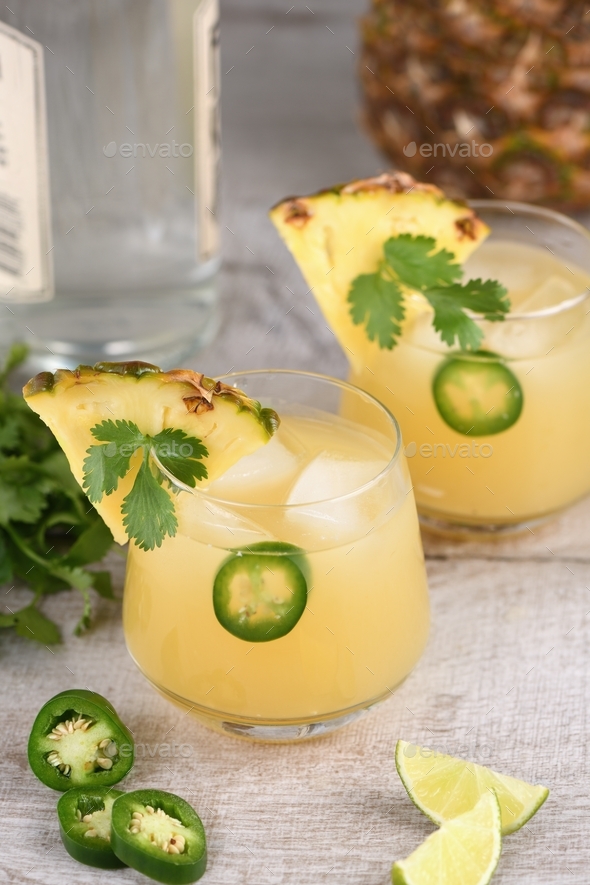 Tequila cocktail with pineapple juice, jalapeno slices and cilantro