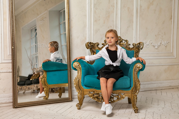 Little princess smiling 4-5 years old blonde girl model in stylish clothe in living room