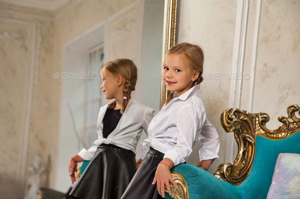 Portrait of little princess smiling 4-5 years old blonde girl model in stylish clothe in living room