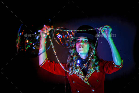 Woman magician illusionist circus in theatrical clothes stylish hat in shows soap bubbles show