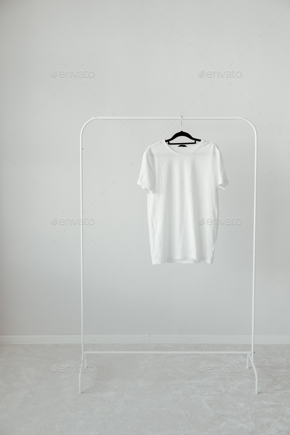 Blank White T-Shirt Mock-up hanging on white Rack Hanger, front view