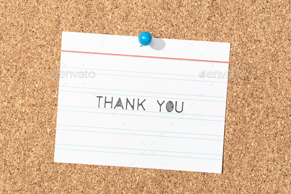 Thank you word phrase made white stencil letters on notepad pinned on cork board