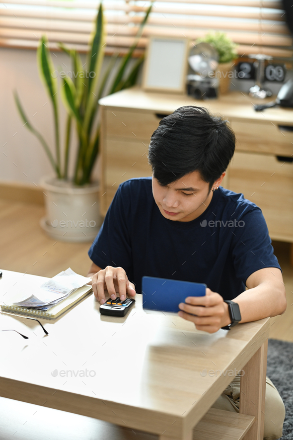Focused man using calculator money bank loan rent payments, managing expenses finances