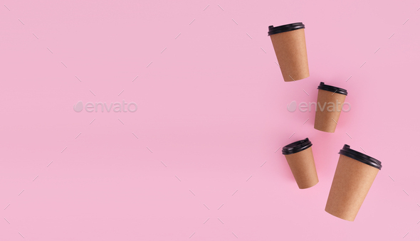 coffee paper cups with place for logo on pink background levitation