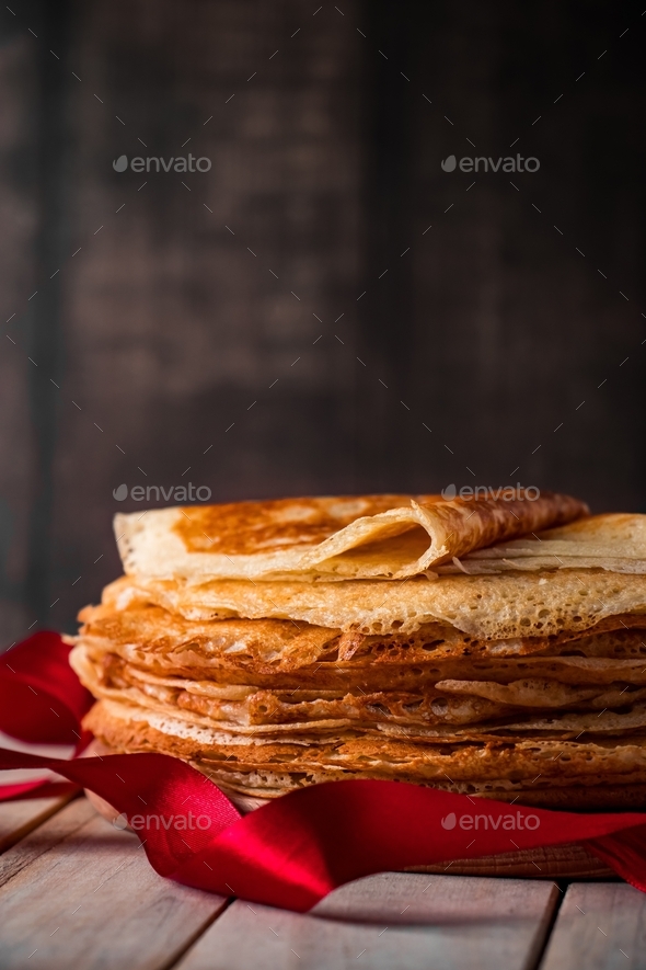Stack of crepes on wooden background. Traditional dish for holiday Fat Tuesday.