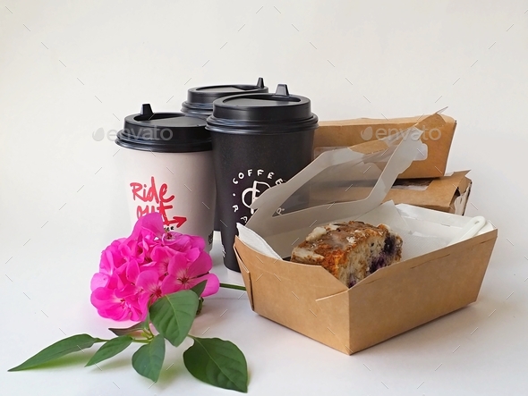 Coffee cups and blueberry cakes in boxes purchased from a takeaway coffee shop on a white background