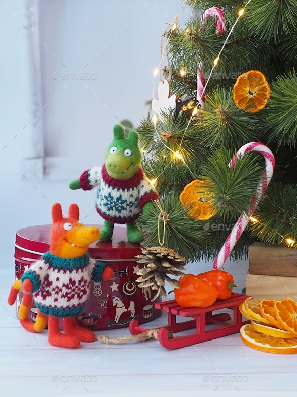 Tiny felt fairy-tale animals in festive sweaters near the Christmas tree