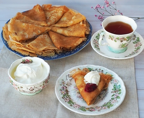 Homemade tea party on Maslenitsa - Russian pancakes bliny with fresh sour cream and tea