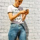Texting and posting girl in front of a brick wall - PhotoDune Item for Sale