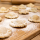 Raw dumplings polish traditional perogies lying on wooden board in kitchen - PhotoDune Item for Sale