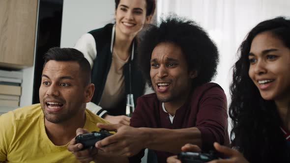 Tilt up video of excited friends playing on game console. Shot with RED helium camera in 8K  alt