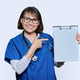 Woman doctor pointing with finger at blank paper on clipboard, white background - PhotoDune Item for Sale