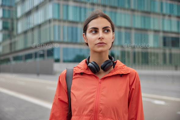Beautiful woman in anorak strolls outdoor has regular sport training to prevent negative mood and st