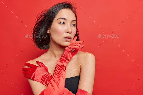 Pensive gorgeous Asian lady wears black dress long gloves dresses for