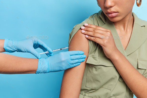 Population immunization concept. Unrecognizable woman gets injection against coronavirus wears dress