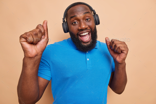 Move your body. Glad bearded man dances in wireless headphones enjoys favorite song sings happily dr