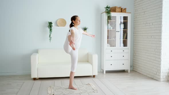 Pregnant Woman Does Utthita Padangusthasana in Room at Home alt