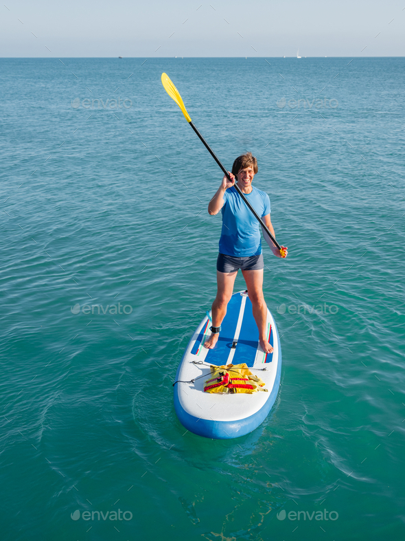 Paddle boarder. Sportsman paddling on stand up paddle board. SUP surfing. Active lifestyle.