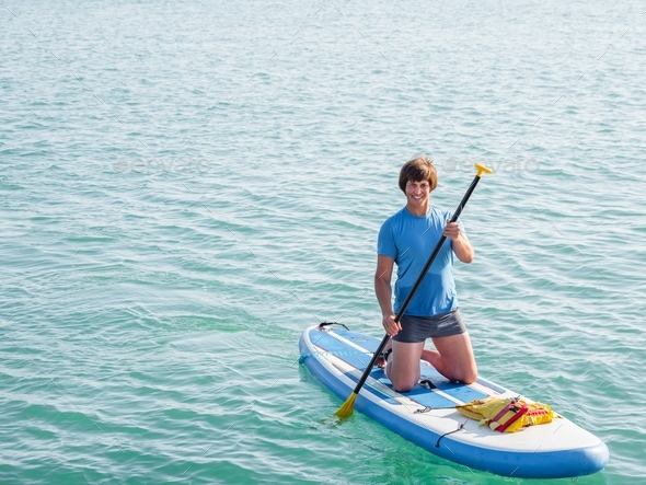 Paddle boarder. Sportsman paddling on stand up paddle board. SUP surfing. Active lifestyle.
