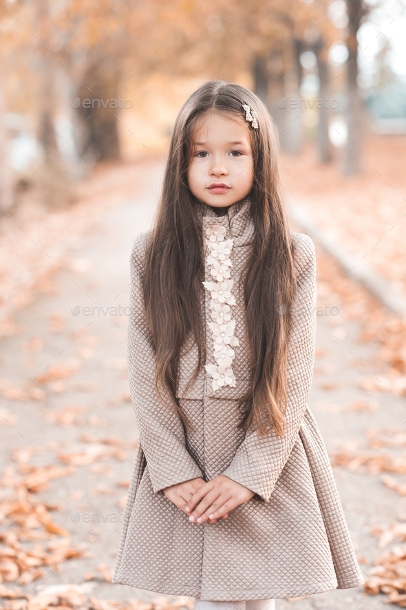 Beautiful kid girl 45 year old wearing stylish autumn jacket in park