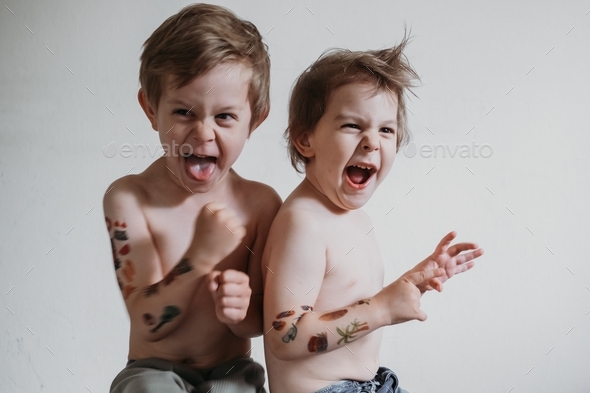 Two Toddler boys with temporary tattoos on hands